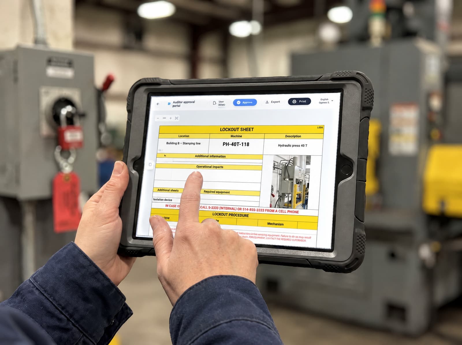 Lockout sheet for a hydraulic press reviewed on a tablet, in front of a locked-out disconnect